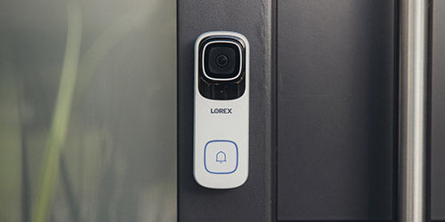 The Lorex 4K Wi-Fi Video Doorbell, a sleek white smart doorbell with a camera and bell icon button, is mounted on a modern doorframe.